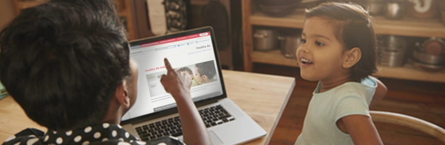Mom and daughter look at healthy air information on laptop