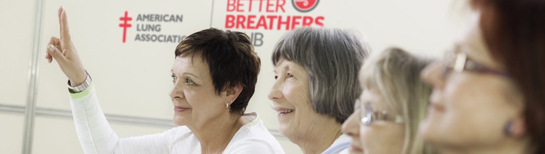 Group of older women in front of Better Breathers Club sign