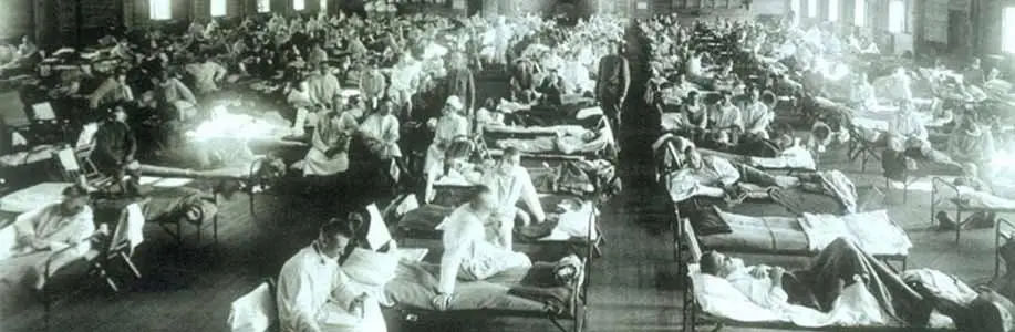 Black and white historical photo shows patients on cots in flu hospital
