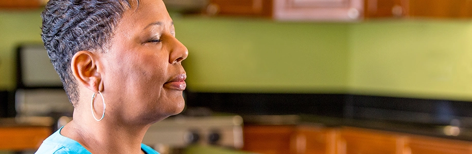 Woman inhales through nose with eyes closed