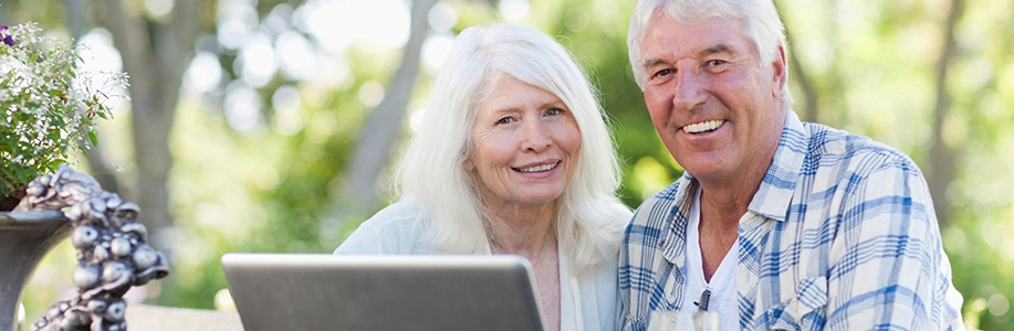 Older couple outside smile at camera